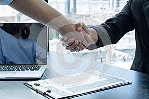 Friendly businessmen and executives shake hands after successful agreement with employment contracts, recruitment, and employment