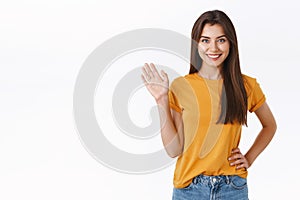 Friendly cheerful, happy smiling woman waving you with raised hand. Attractive girl greeting friend, say hello or hi