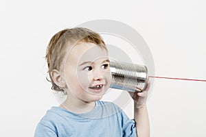 Friendly child listening to tin can phone