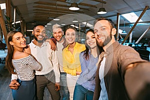 Friendly colleagues taking selfie at coffee break