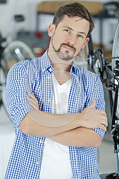 Friendly and competent bicycle mechanic in workshop posing photo