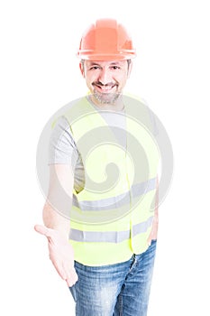 Friendly construction worker smiling and doing a hand shake gesture