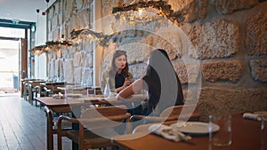 Friendly couple gossiping restaurant enjoying cozy atmosphere. Two women talking