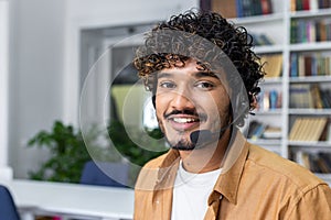 Friendly customer service representative with headset smiling in office