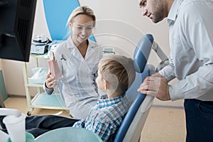 Friendly Dentist Working with Little Kid in Clinic