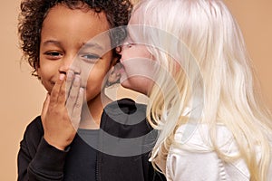 Friendly diverse children play, tell stories and secrets to each other