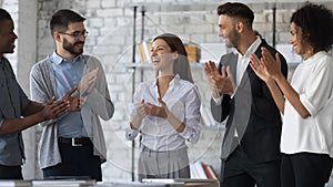 Friendly diverse employees congratulating businesswoman with business achievement photo