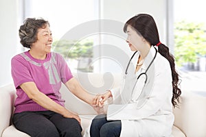Friendly doctor caring senior woman indoor room