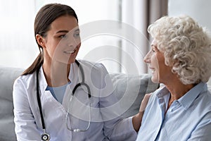 Friendly doctor consulting older woman patient during visit close up