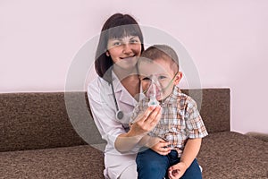 Friendly doctor doing inhalation with nebulizer to a boy