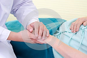 Friendly doctor holds the woman patient`s hand to encourage and trust medical treatment with heart at the hospital.