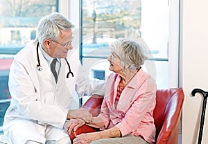 Friendly doctor reassuring an elderly woman.