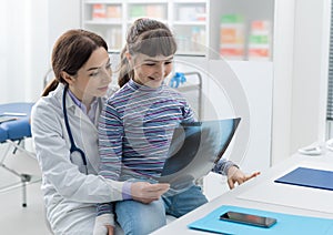 Friendly doctor showing an x-ray to a young patient