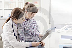 Friendly doctor showing an x-ray to a young patient