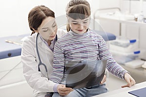 Friendly doctor showing an x-ray to a young patient