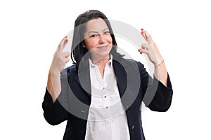 Friendly entrepreneur woman making good luck gesture with hands