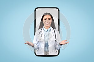 Friendly european female doctor with stethoscope emerges from smartphone screen, engaging with welcoming gesture