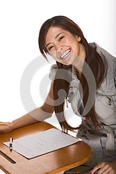 Friendly excited Asian college student by desk