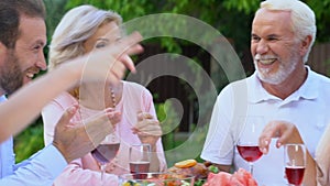 Friendly family communicating and laughing having lunch outdoor pleasure pastime