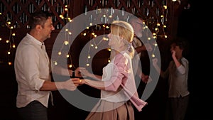 Friendly family dancing in a restaurant. Portrait Of Happy married couple Dancing On Bokeh Background. Wedding