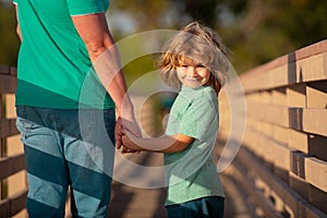 Friendly family. Happy father and son. Son stretching out hands father. Handsome man and cute boy outdoor.