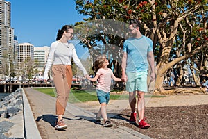 friendly family having fun in summer. happy parents leading kid boy.