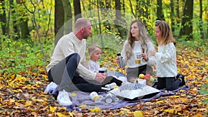 Friendly family having a picnic in the autumn forest