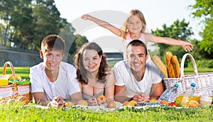 Friendly family lying on green lawn at picnic