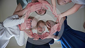 A friendly family makes a circle out of their hands.