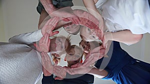 A friendly family makes a circle out of their hands.