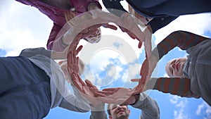 A friendly family makes a circle out of their hands against the blue sky