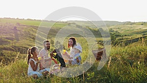 Friendly family on a picnic with a dog in nature