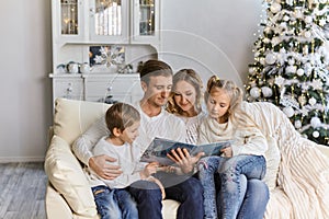 Friendly family reading book on Christmas evening