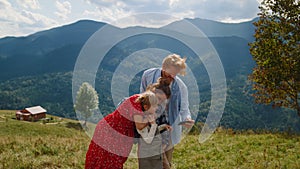 Friendly family using smartphone in mountains. Couple with kids looking to phone