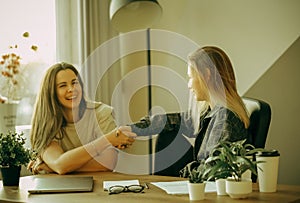 Friendly female colleagues having good relationships, pleasant conversation at workplace during coffee break