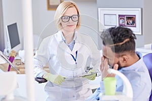 Friendly Female Dentist Listening to Patient