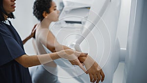 Friendly Female Doctor Explains the Mammogram Procedure to a Topless Latin Female Patient with Cur