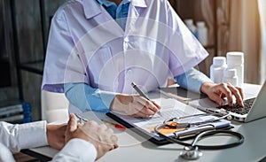 Friendly female doctor hands holding patient hand sitting at the desk for encouragement, empathy, cheering.