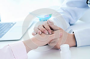 Friendly female doctor hands holding patient hand sitting at the desk for encouragement, empathy, cheering and support