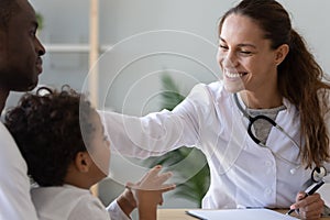 Friendly female doctor stroke head of cute african child boy