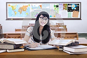 Friendly female high school student studying in class