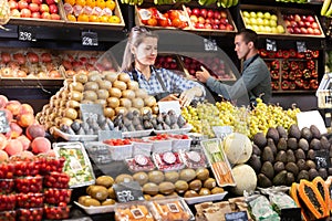 Friendly female and man laying out vegetables photo