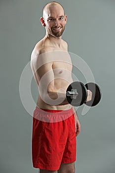 Friendly fitness man holding dumbbell