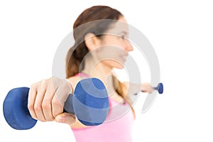 Friendly fitness woman holding dumbbells with both arms