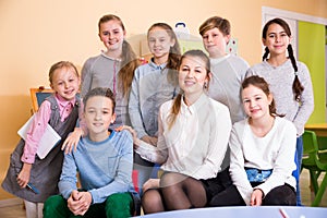 Friendly group of pupils with teacher in schoolroom photo