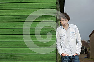 Friendly Guy Leaning against a Wooden Wall