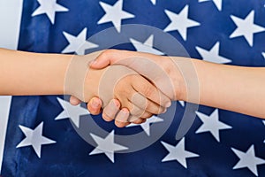 Friendly handshake of people on the background of the American flag