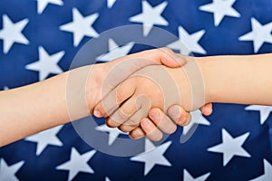 Friendly handshake of people on the background of the American flag