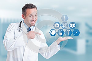 Friendly handsome medic holding digital buttons with medical icons