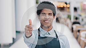 Friendly happy african american male worker waiter salesman in apron man shows good perfect sign with hand small